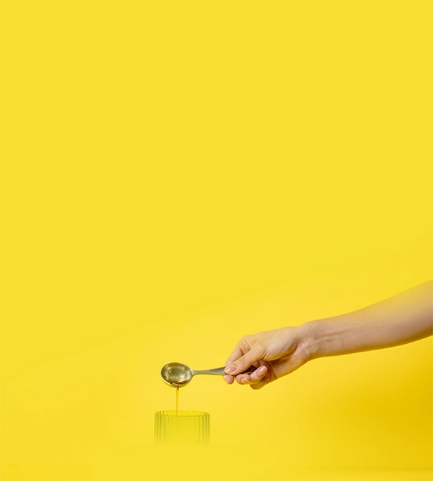 hand pouring olive leaf extract liquid into a glass