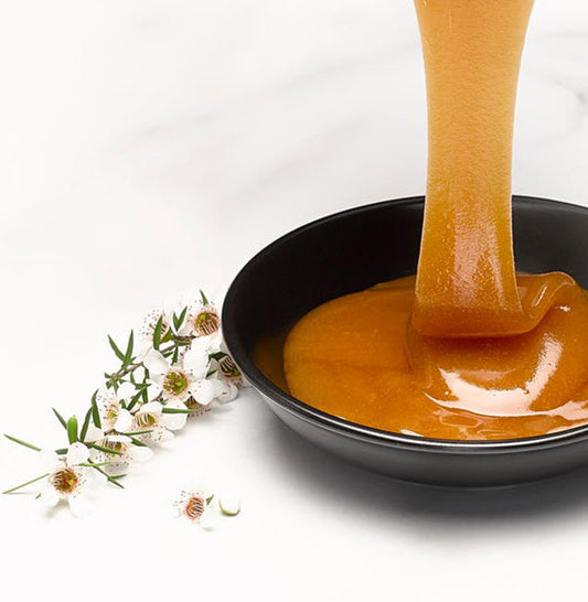 Manuka honey dripping into dish