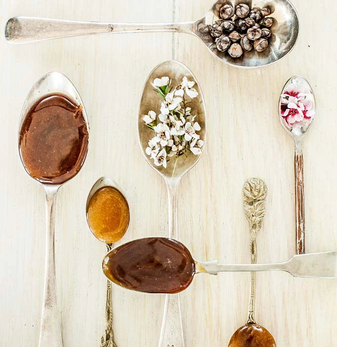 spoons of manuka flowers, seeds and honey